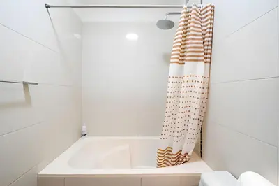a bathroom with a tub and a shower curtain at Central Bloom Miraflores in Lima
