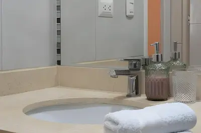 a bathroom sink with a white towel on a counter at Central Bloom Miraflores in Lima