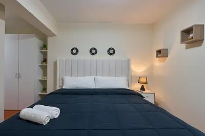 a bedroom with a blue bed with towels on it at Apartamento moderno cerca del Parque Wallenberg in Lima