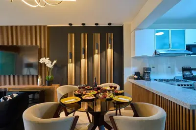 a kitchen with a table and chairs in a kitchen at Apartamento moderno cerca del Parque Wallenberg in Lima