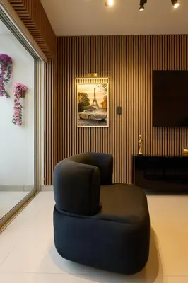 a living room with a blue chair and a television at Apartamento moderno cerca del Parque Wallenberg in Lima