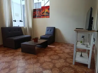 a living room with a couch and a chair and a table at bambanhouse in Cusco