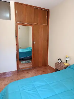 a bedroom with a bed and a cabinet with a mirror at bambanhouse in Cusco