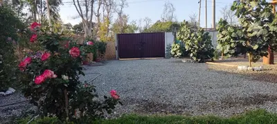 a garage with a door in a yard with pink roses at Casa rústica in Ica
