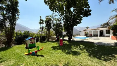 a yard with a house and a toy playground at Casa Huerta Vista Bonita in Canta