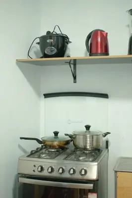 two pots and pans on a stove in a kitchen at Mini departamento con cochera in Ayacucho