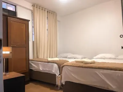 a room with two beds and a window at Mini departamento con cochera in Ayacucho
