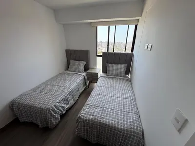 two beds in a room with a window at Cozy Room in Miraflores with rooftop pool in Lima