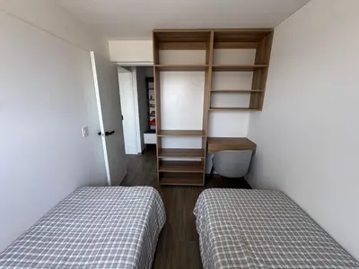 a bedroom with two beds and a book shelf at Cozy Room in Miraflores with rooftop pool in Lima