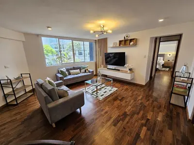 a living room with a couch and a television at Apartamento renovado en Miraflores in Lima