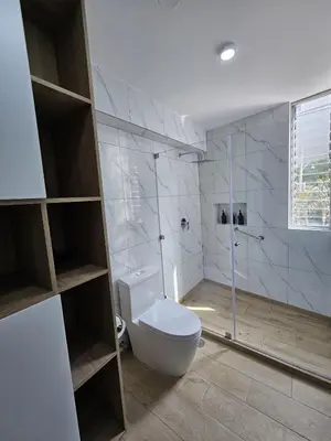 a bathroom with a toilet and a glass shower at Apartamento renovado en Miraflores in Lima