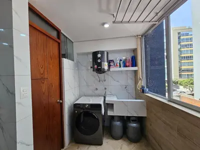 a bathroom with a washing machine and a sink at Apartamento renovado en Miraflores in Lima