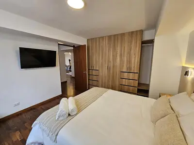 a bedroom with a bed with two white towels on it at Apartamento renovado en Miraflores in Lima