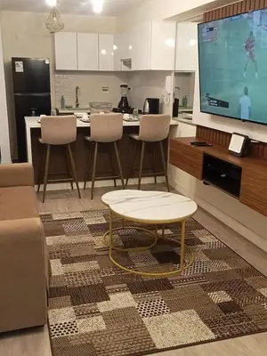 a living room with a table and a large tv at Edificio The sight Barranco vista al mar in Lima