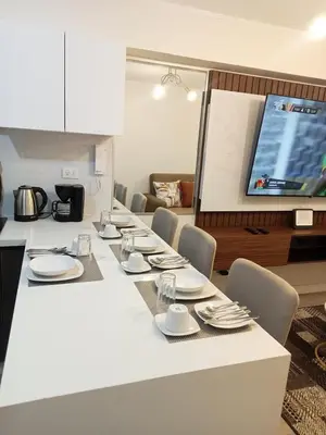 a white table with chairs and plates and a tv at Edificio The sight Barranco vista al mar in Lima