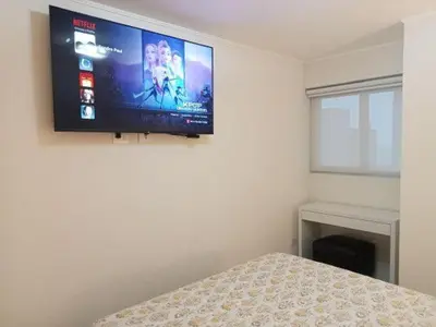 a bedroom with a flat screen tv on the wall at Edificio The sight Barranco vista al mar in Lima