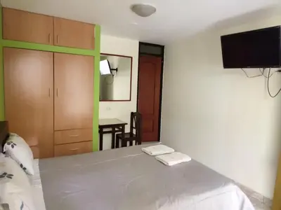 a bedroom with a bed and a tv on the wall at Hotel Misky Samay in Ayacucho