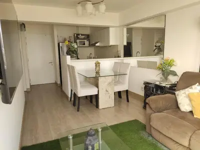 a kitchen and living room with a table and a couch at Departamento Costa Verde San Miguel in Lima