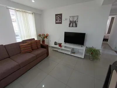 a living room with a couch and a flat screen tv at Apartamento en Cusco III in Cusco