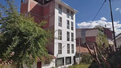 a white building with a red brick tower at Apartamento en Cusco III in Cusco