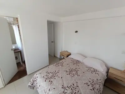 a bedroom with a bed in a white room at Apartamento en Cusco III in Cusco