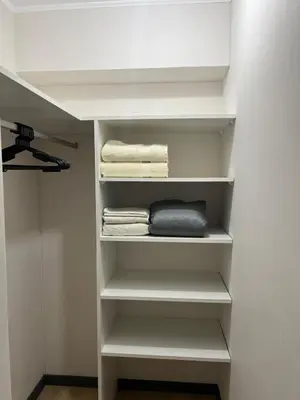 a walk in closet with white shelves and towels at Beautiful Modern Apartment in Lima in Lima