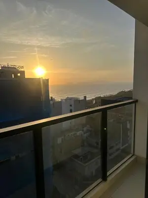 a view of the sunset from the balcony of a building at moderno departamento con vista al mar en miraflores in Lima