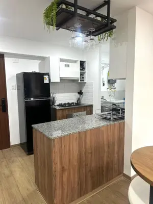 a kitchen with a black refrigerator and a counter at moderno departamento con vista al mar en miraflores in Lima
