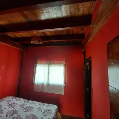 a red room with a bed and a window at Linda Casa de playa con vista al mar de Wakama in Jaguay