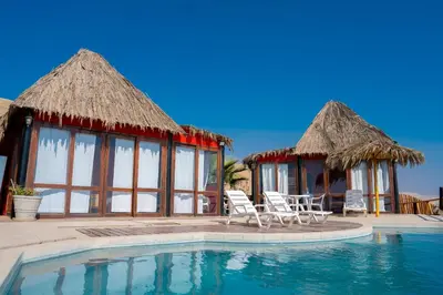 a villa with a swimming pool and two chairs at Linda Casa de playa con vista al mar de Wakama in Jaguay