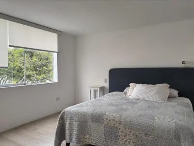 a bedroom with a bed with a blanket and a window at Casa amplia y acogedora, en Miraflores in Lima
