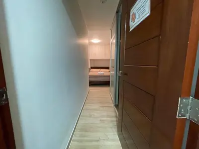 a hallway with a door and a bed in a room at Casa de Moño - Moderno apartamento cerca a Aeropuerto y Terminal Terrestre in Lima
