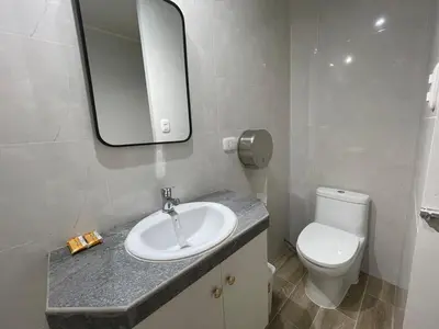 a bathroom with a sink and a toilet and a mirror at Casa de Moño - Moderno apartamento cerca a Aeropuerto y Terminal Terrestre in Lima