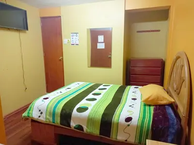 a bedroom with a bed with a colorful blanket at Hospedaje Bienvenidos a mi Casa in Cerro de Pasco