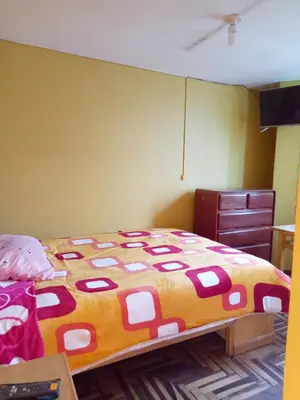 a bedroom with a bed with a colorful comforter at Hospedaje Bienvenidos a mi Casa in Cerro de Pasco