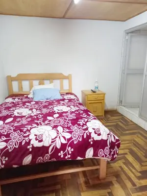 a bedroom with a bed with a purple comforter at Hospedaje Bienvenidos a mi Casa in Cerro de Pasco
