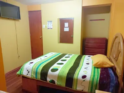 a bedroom with a bed with a colorful blanket at Hospedaje Bienvenidos a mi Casa in Cerro de Pasco