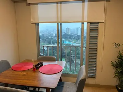 a dining room with a table and a large window at Magical View Parque de las Aguas, central apartment in Lima