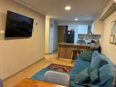 a living room with a blue couch and a kitchen at Magical View Parque de las Aguas, central apartment in Lima