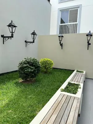 a garden with a wooden bench in front of a house at Apartment overlooking the water park in Lima