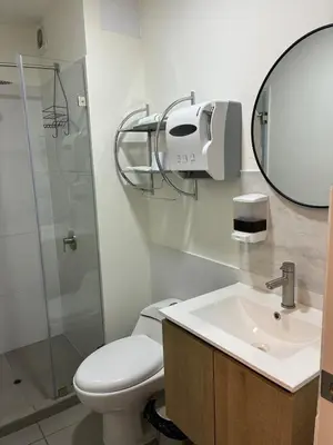 a bathroom with a toilet and a sink and a mirror at Spacious downtown apartment overlooking Parque de las Aguas in Lima