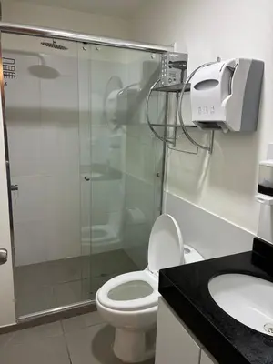 a bathroom with a shower and a toilet and a sink at Spacious downtown apartment overlooking Parque de las Aguas in Lima