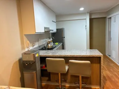 a kitchen with a counter and two bar stools at Spacious downtown apartment overlooking Parque de las Aguas in Lima