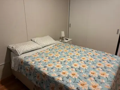 a bedroom with a bed with a blue and yellow flower comforter at Spacious downtown apartment overlooking Parque de las Aguas in Lima