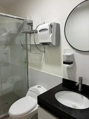 a bathroom with a toilet and a sink and a mirror at Spacious downtown apartment overlooking Parque de las Aguas in Lima