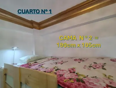 a bedroom with a bed with pink flowers on it at Centro Historico Lima - Apartamento in Lima