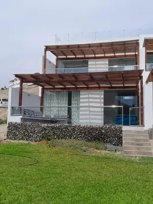 a house with a stone wall in front of it at Beach house - Alto Bujama Condominium in Asia
