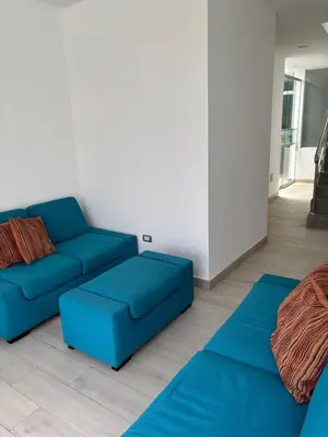 a living room with a blue couch and a rug at Beach house - Alto Bujama Condominium in Asia