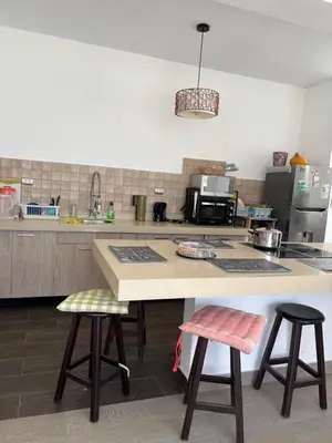a kitchen with a counter and two bar stools at Beach house - Alto Bujama Condominium in Asia
