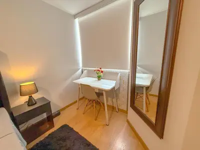a room with a mirror and a table and a lamp at Modern XXL Apartment in San Miguel in Lima